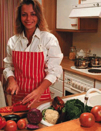 Photo of a woman in the kitchen cutting vegetables