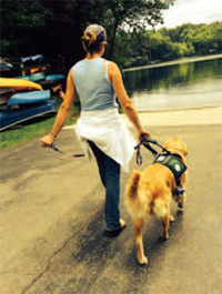 Photo of Tina walking with her service dog Crane