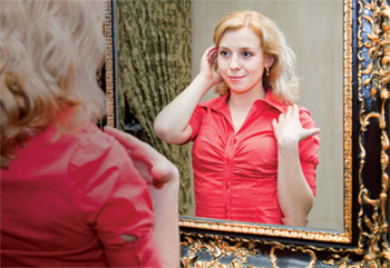 Photo of a woman looking at herself in a mirror